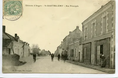 La rue principale de la ville, avec des cyclistes. Photo ancienne