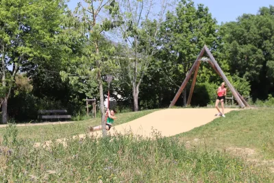 La passerelle surplombant le bassin du parc de l'Europe. Une personne s'y balade en été.